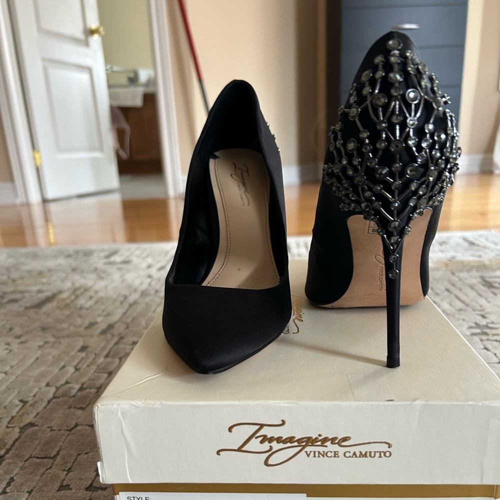 High heel satin pumps with embellishment at the heel.